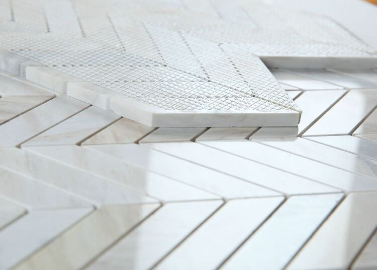 Chevron Eurasian 11 x 11 marble mosaic tiles in grey and beige with polished finish.