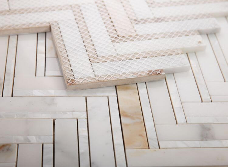 Diana Herringbone Calacatta mosaic tiles in white and gold, featuring marble and mother of pearl elements.
