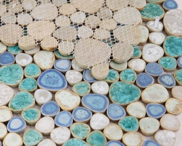 Close-up of Poseidon Sea Pebble mosaic tile showcasing textured, colorful porcelain pebbles for a modern pool design.