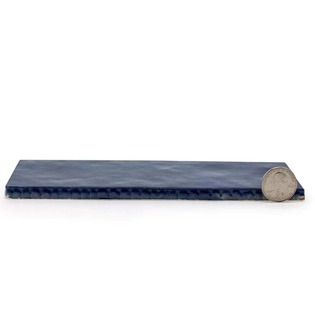 Cloé 2.5" x 8" glossy blue ceramic tile with coin for size reference.