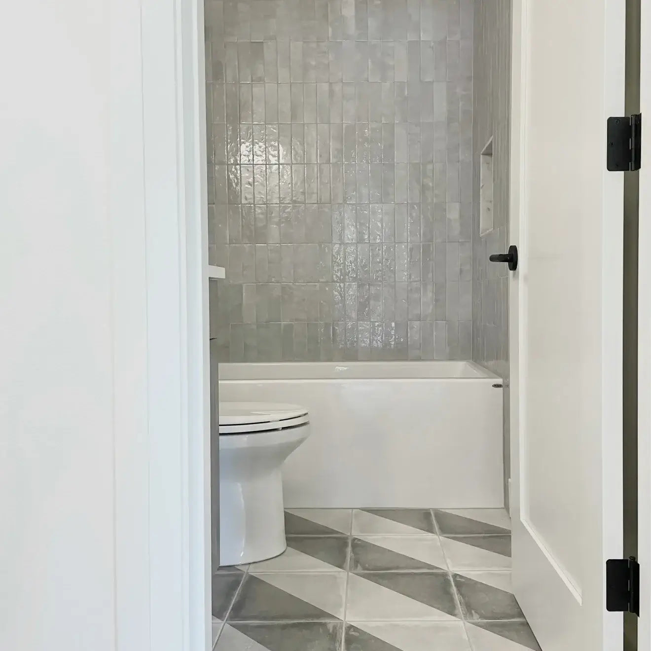 Modern bathroom featuring Cloé 2.5" x 8" glossy grey ceramic tile and stylish patterned floor tiles.