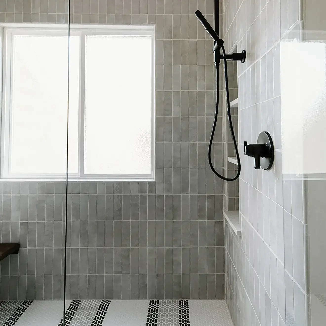 Modern shower design featuring grey ceramic tiles, sleek showerhead, and glass enclosure for a chic look.