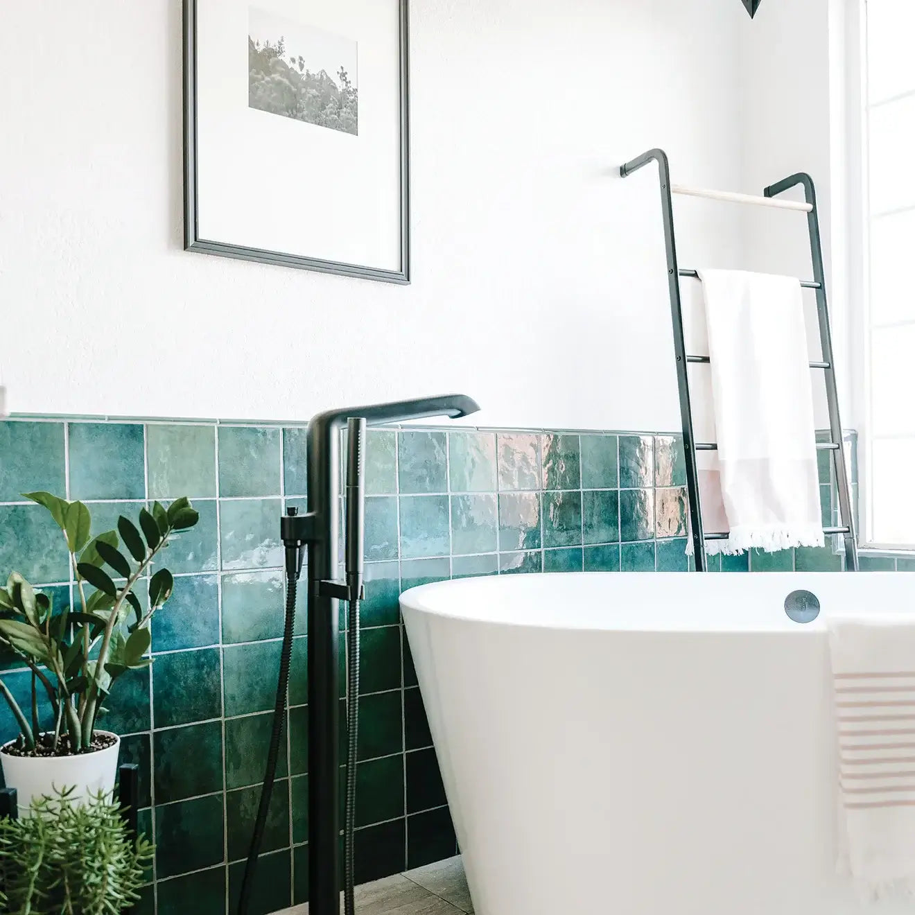Bright bathroom featuring a white bathtub and green glossy ceramic tiles, creating a refreshing and modern aesthetic.