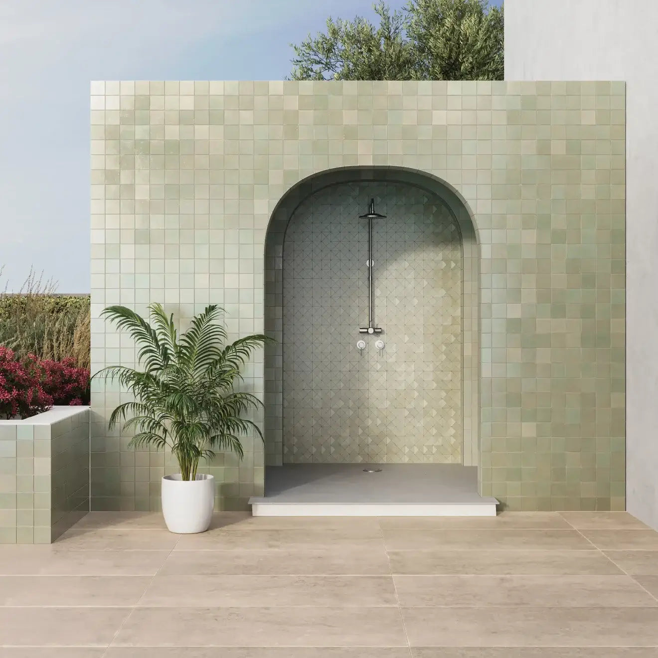 Outdoor shower with green mosaic tiles and a potted plant, creating a serene and stylish bathing area.
