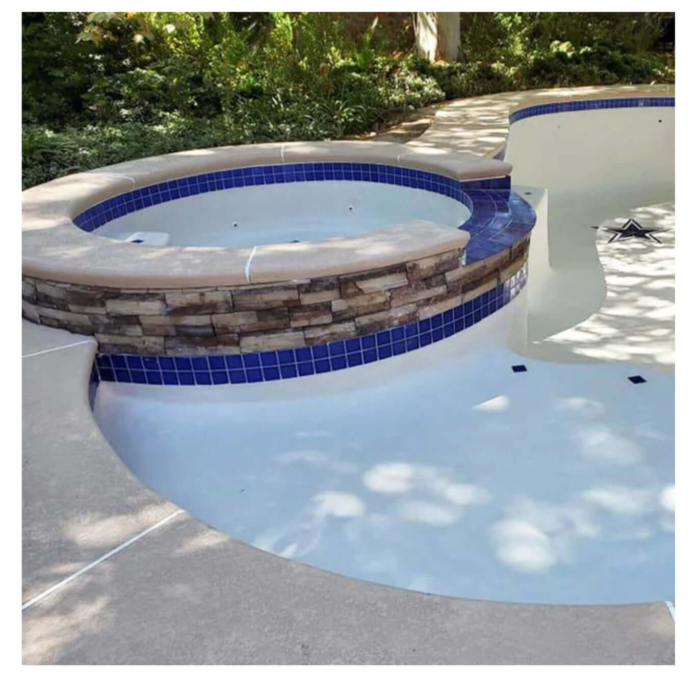 Fujiwa Tile VIP 3x3 Cobalt Blue mosaic tiles in a pool design with stone accents and surrounding landscape.