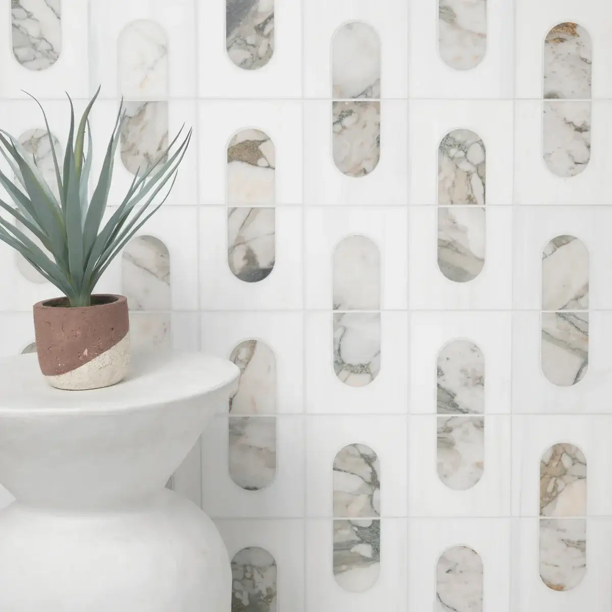 Bianco Dolomite Green marble mosaic wall tile with modern geometric patterns and potted plant.
