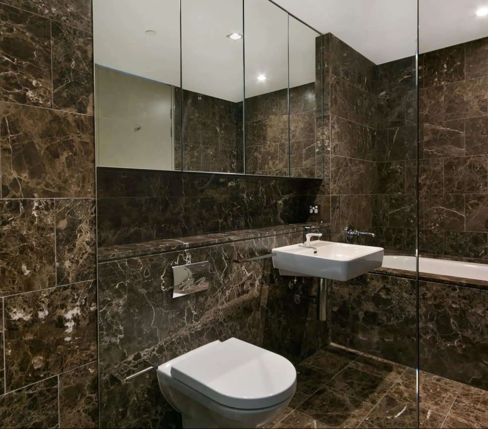 Luxurious bathroom featuring 12x12 Iberian Emperador Dark Marble walls, reflecting modern elegance and sophistication.