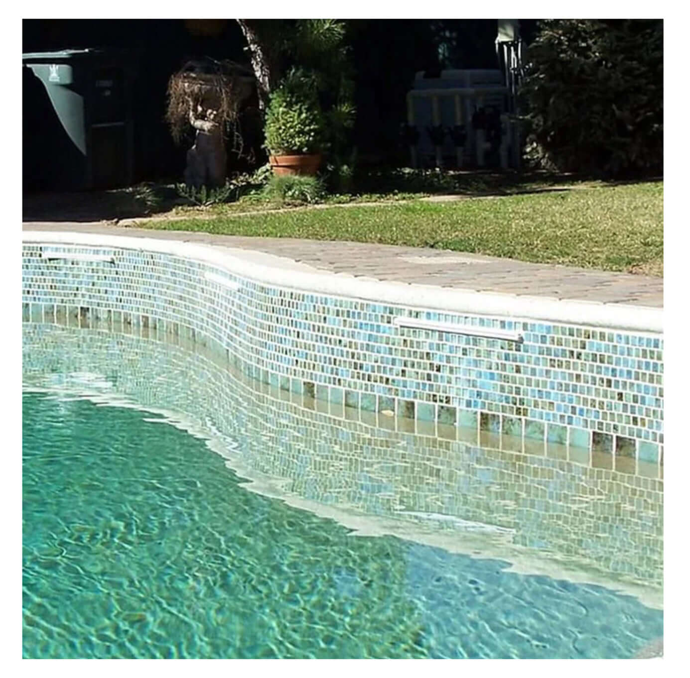 Vibrant green porcelain tiles along the edge of a shimmering pool, enhancing the outdoor oasis.