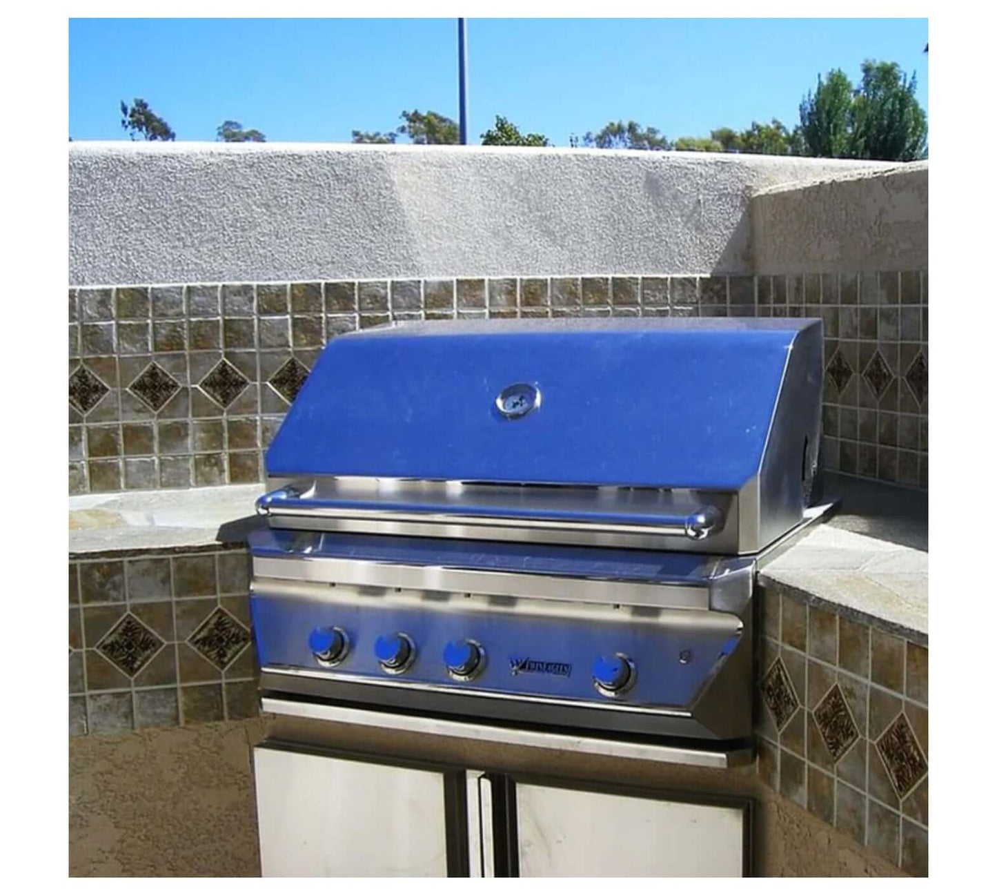 Stylish stainless steel barbecue grill on a tiled outdoor countertop with decorative stone accents.