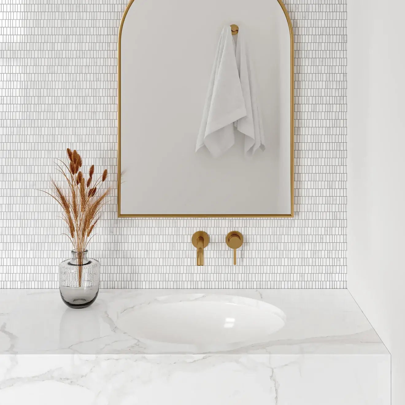 Elegant bathroom featuring a marble sink, gold fixtures, and textured white mosaic tile backsplash.