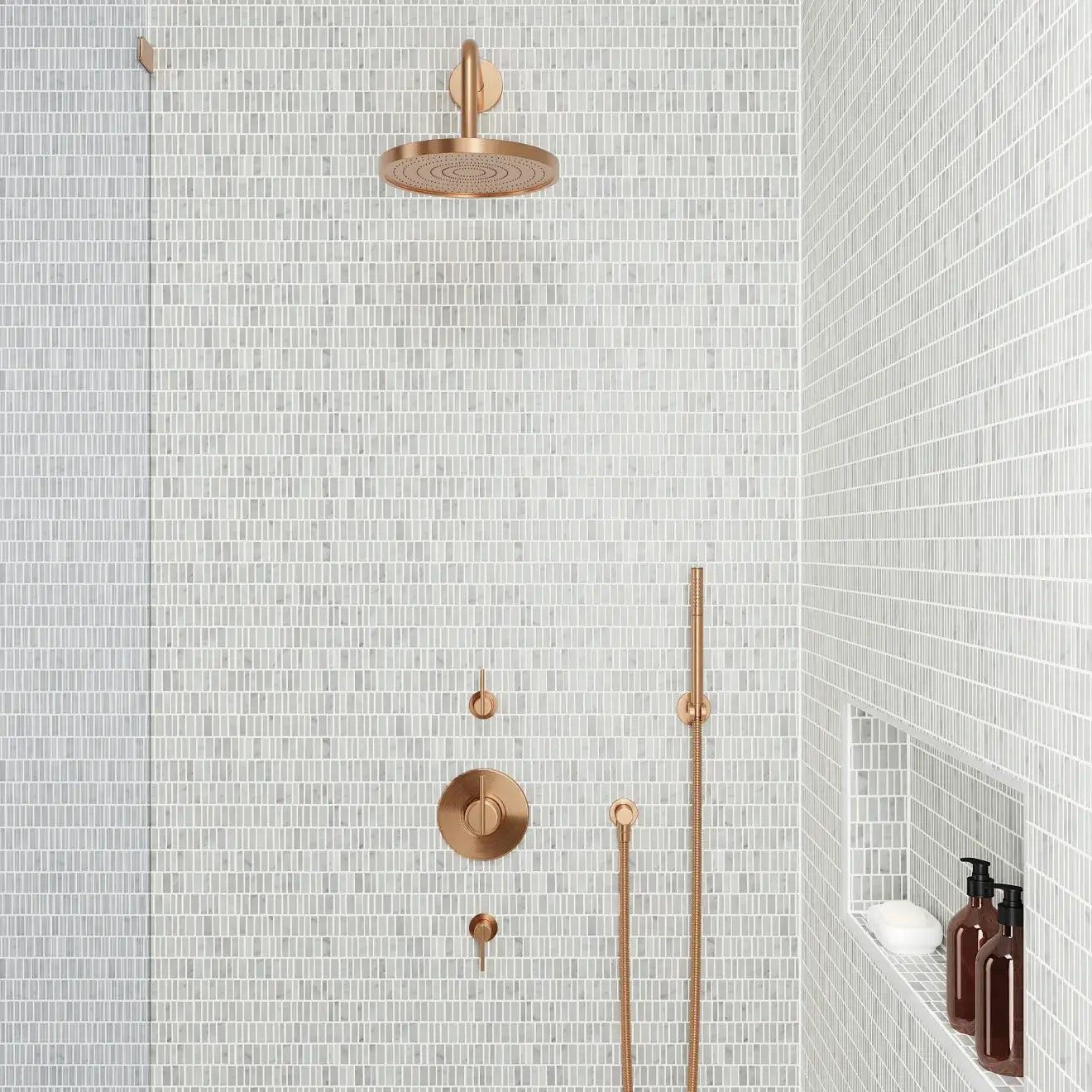 Modern shower with textured white tiles, a sleek bronze showerhead, and elegant fixtures for a contemporary look.