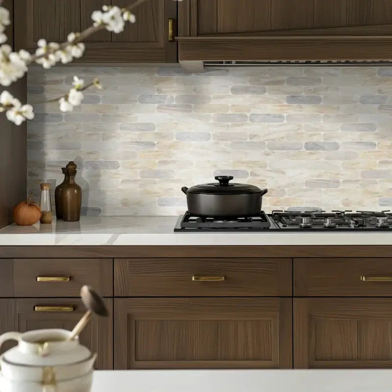 Modern kitchen featuring a sleek gas stove and stylish backsplash in soft, neutral tones.