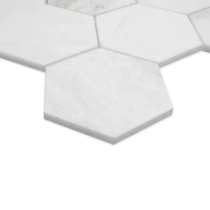 Close-up of 5” Arabescato Venato white hexagon marble mosaic tiles showcasing their sleek, honed surface.
