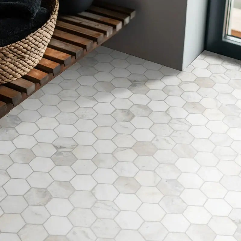 Honed white hexagon marble mosaic tile flooring in a modern interior setting with wooden shelf.