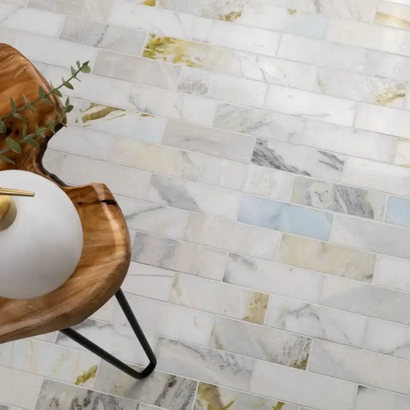Cloudland 2x6 polished marble subway mosaic tile flooring with natural stone veining, styled with a wooden chair and decor.