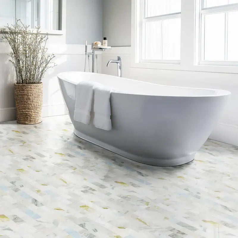 Elegant bathroom featuring Cloudland 2x6 polished marble subway mosaic tile flooring and a modern freestanding bathtub.
