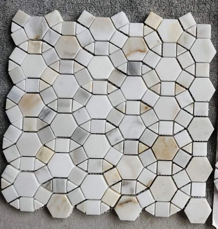 Aether Calacatta 11.5x12 mosaic featuring intricately arranged hexagons, squares, and triangles in elegant Calacatta marble.