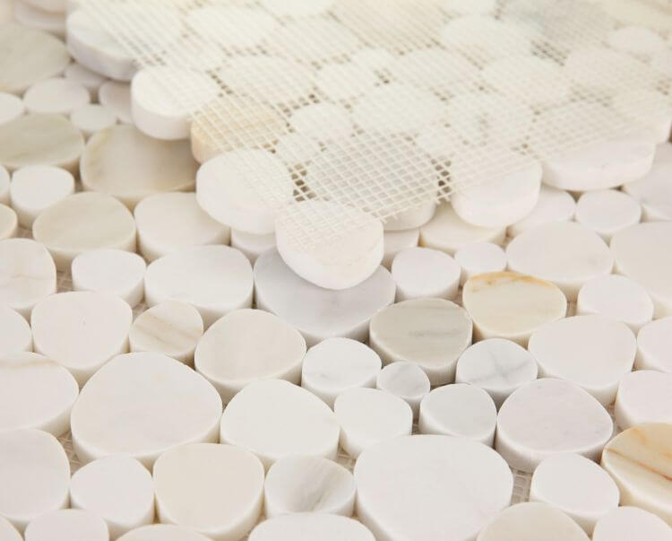 Calacatta Gold Pebble Mosaic Tile 12x12 featuring elegant white marble pebbles arranged on a mesh backing.