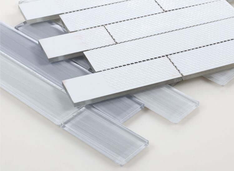 Polished light grey glass tiles in subway layout for swimming pool installation.