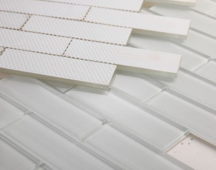 Polished light grey glass tiles in subway layout, perfect for swimming pool installation with recommended thin-set and grout.