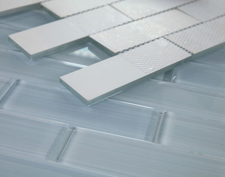 Close-up of Casale Lucy Blue hand-painted glass tiles in subway layout, ideal for swimming pool installation.