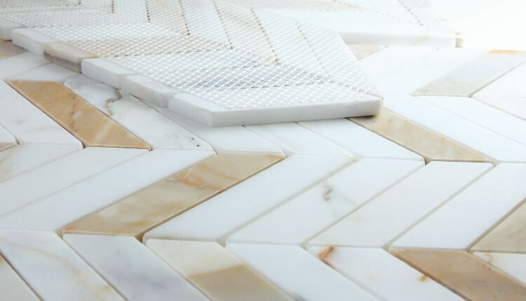 Chevron Calacatta Gold honed marble mosaic tile, showcasing elegant white and gold veining in a stylish pattern.