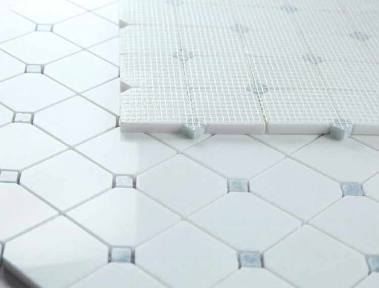 Close-up of Thassos Blue Diamond mosaic tile with geometric clipped pattern and white marble finish.