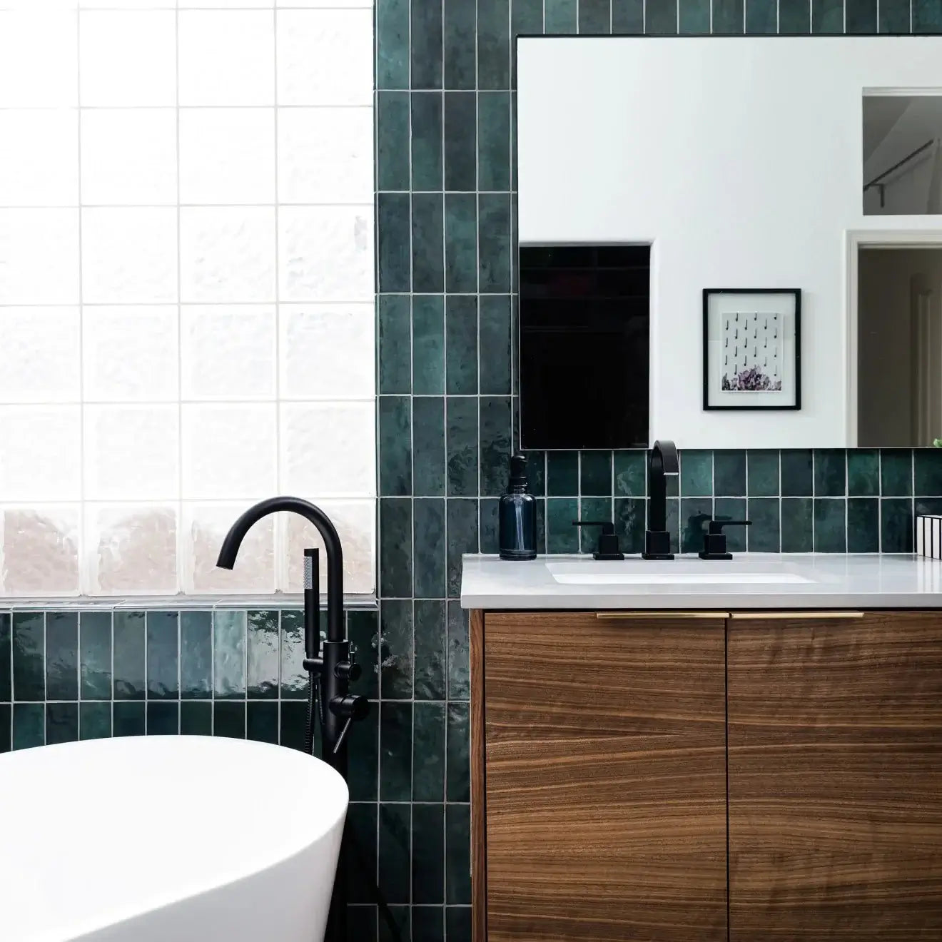 Stylish bathroom featuring green glossy ceramic tiles, a modern freestanding tub, and chic wooden cabinetry.
