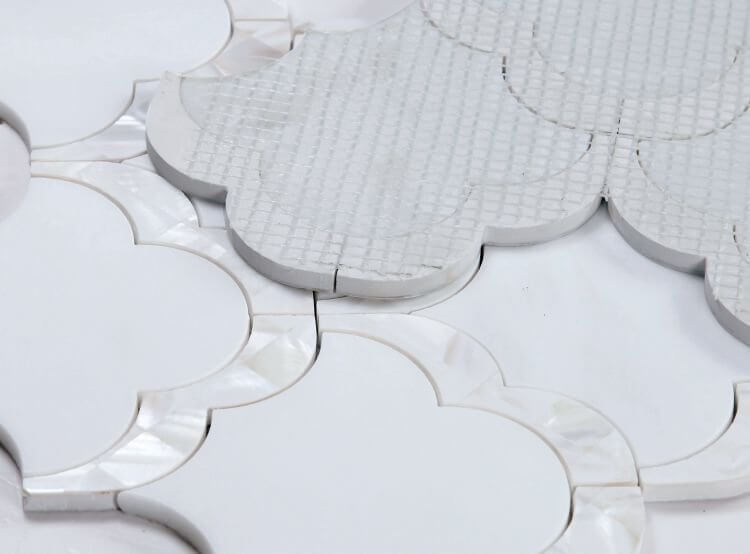 Diana Scale 10.5x12 marble and mother-of-pearl mosaic tile, featuring an artistic scale-like pattern in white.
