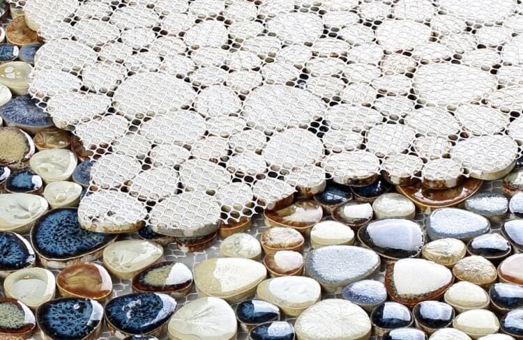 Close-up of Poseidon Blue 11.50 x 11.50 Pebble Mosaic Tile showcasing varying blue and earth-toned pebbles for pool design.