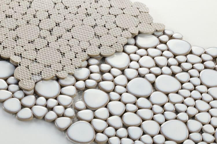 Close-up of Poseidon Fancy White Pebble Mosaic Tile showcasing smooth white pebbles on a mesh sheet.